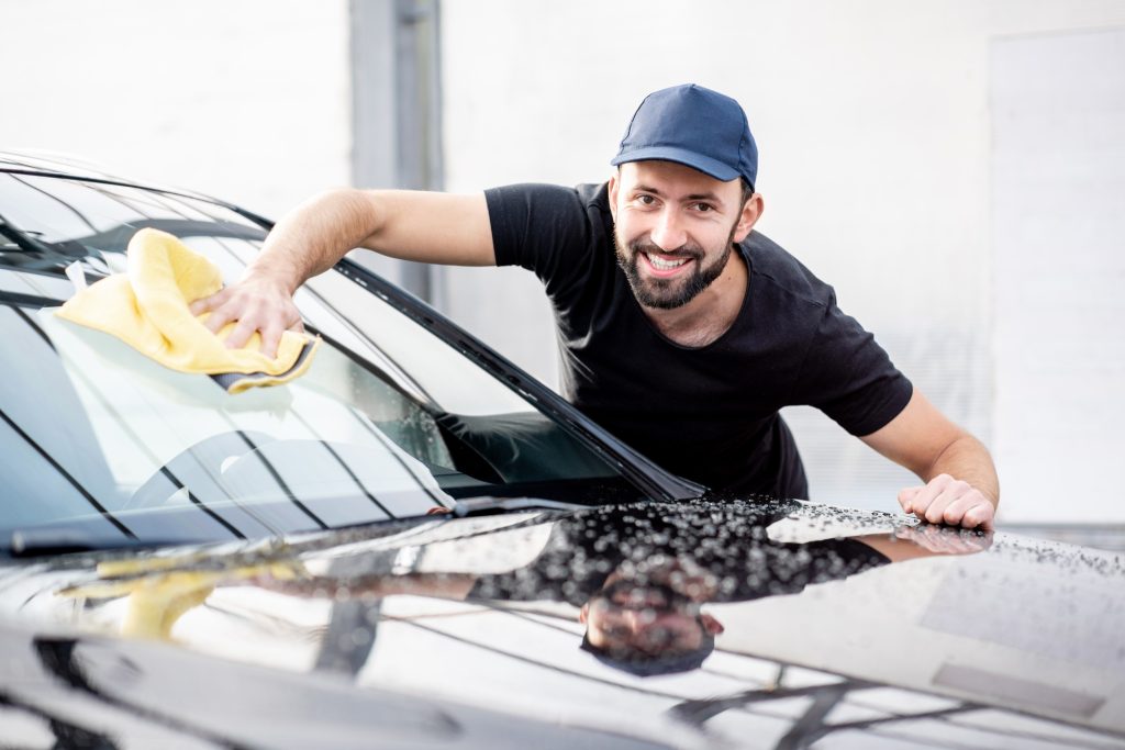 Handsome washer wiping car windshield